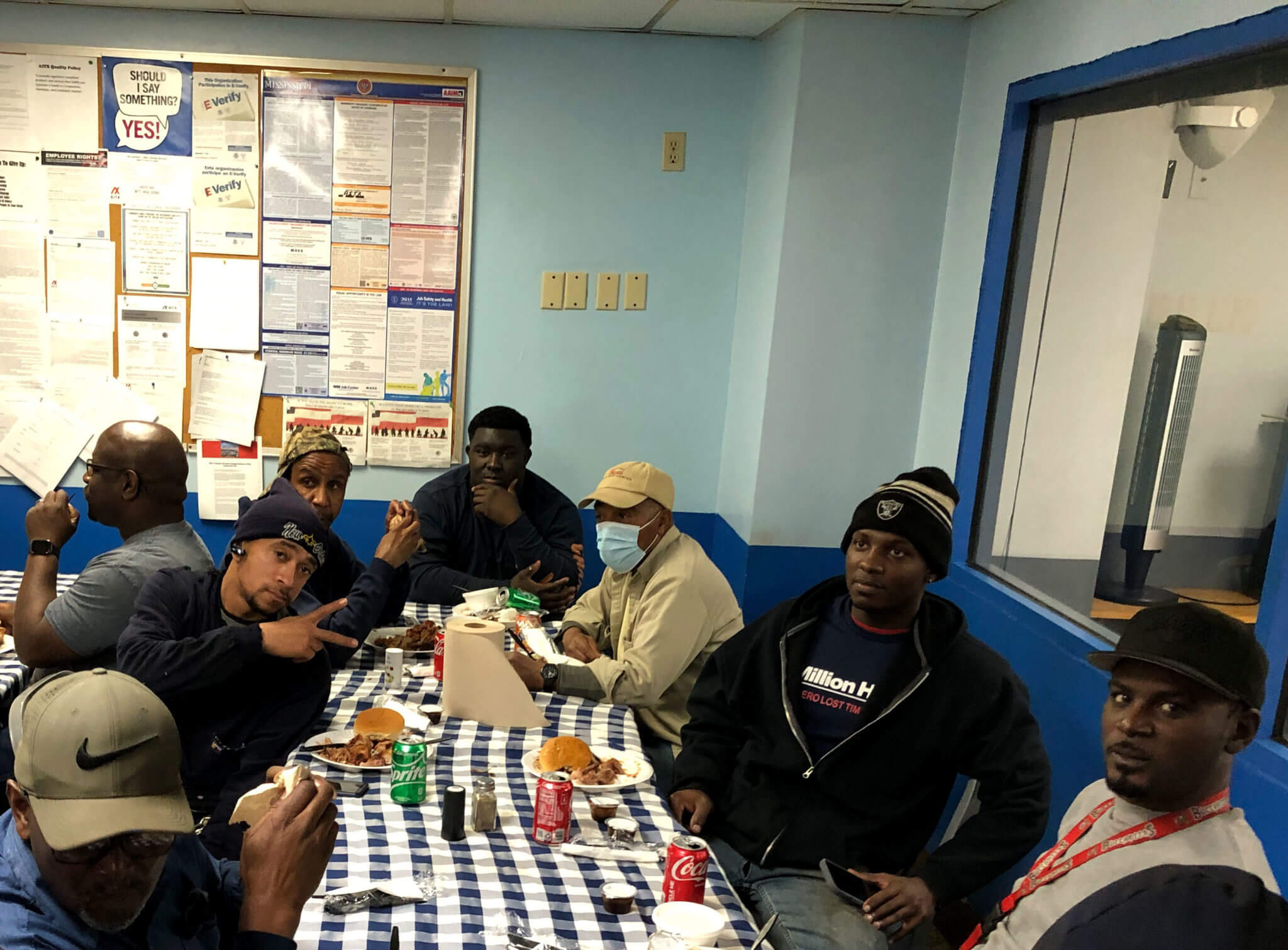 Group of employees at Bude, MS enjoying a meal together, celebrating over 1 million hours with zero lost time to injuries, in a break room with blue walls and a bulletin board in the background.