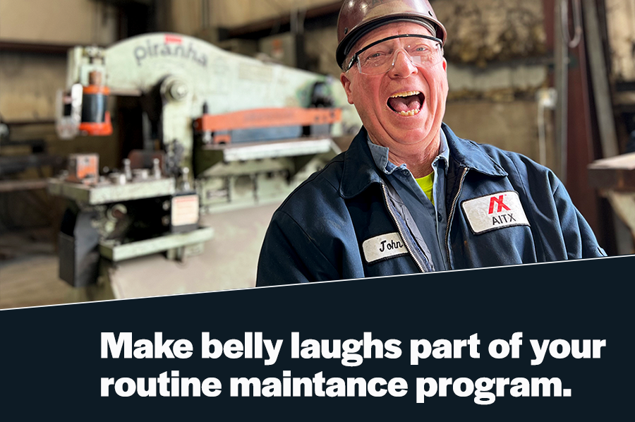 A smiling factory worker in safety gear stands in front of a large industrial machine, promoting a positive work environment. The image emphasizes the importance of humor and joy in routine maintenance programs.