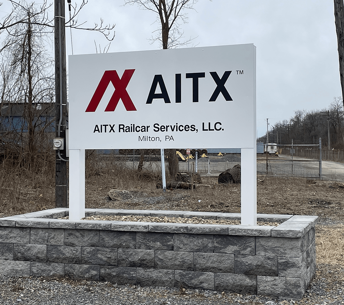 Signage for AITX Railcar Services, LLC located in Milton, PA, featuring the company logo and name prominently displayed.