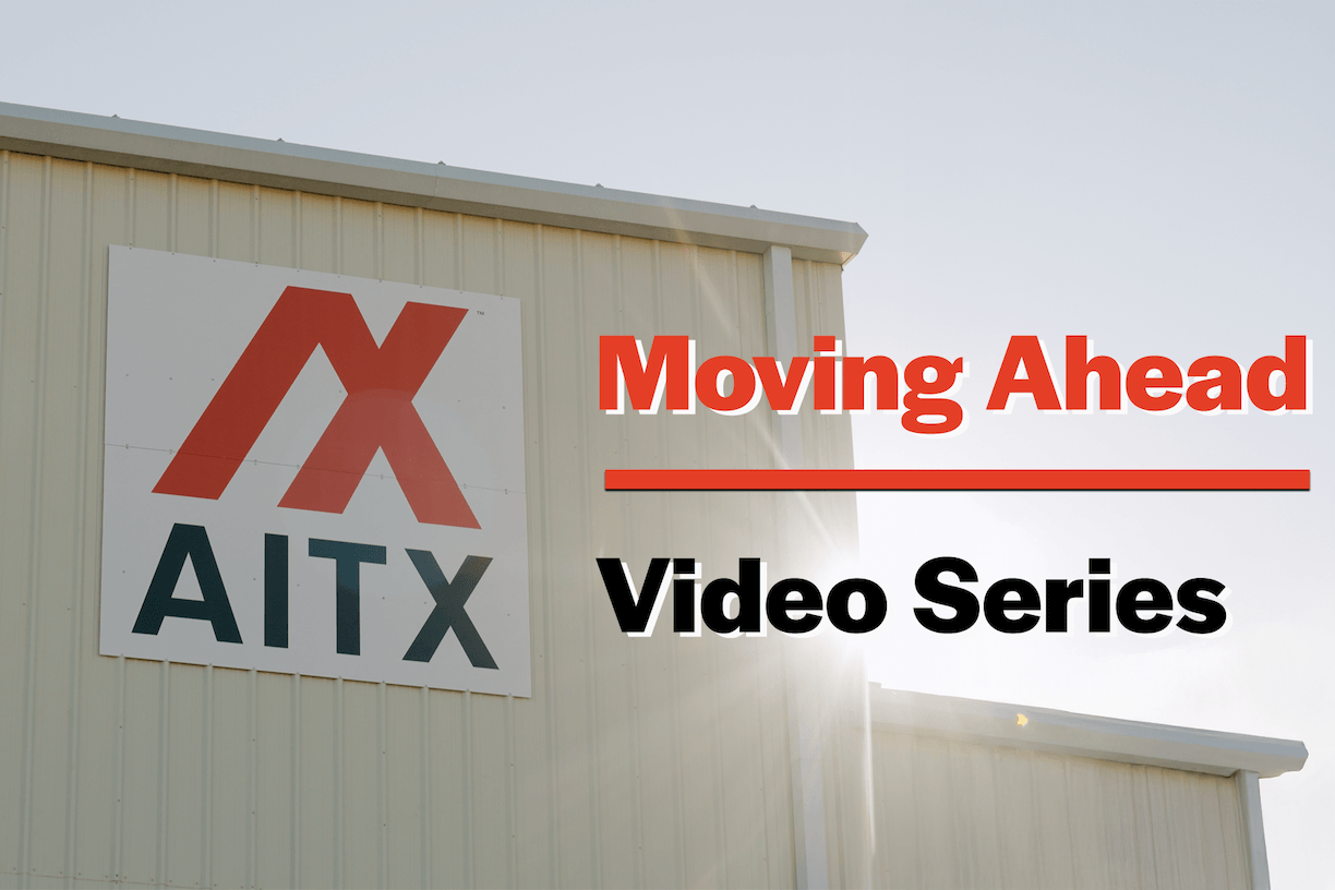 AITX company sign featuring the tagline "Moving Ahead Video Series," highlighting the brand's focus on innovation and progress in technology and security solutions.